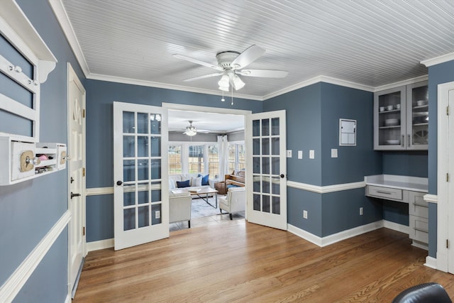 home office featuring wood finished floors, french doors, and built in study area