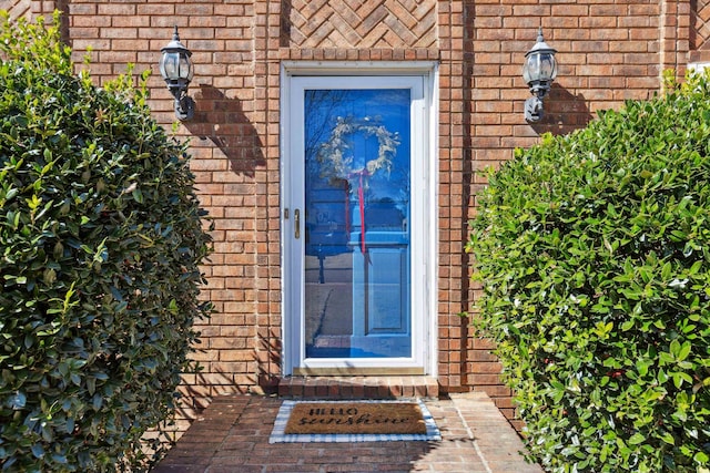 view of exterior entry featuring brick siding