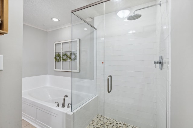 bathroom featuring a stall shower, a textured ceiling, ornamental molding, and a bath