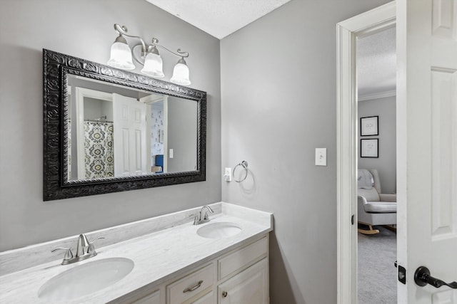 bathroom featuring double vanity, a textured ceiling, and a sink