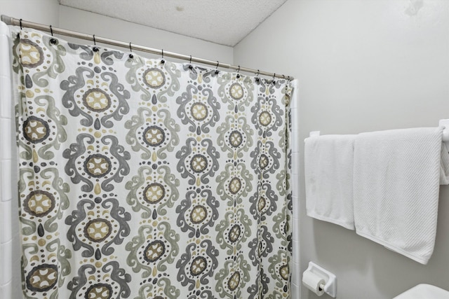 bathroom featuring a textured ceiling and a shower with shower curtain