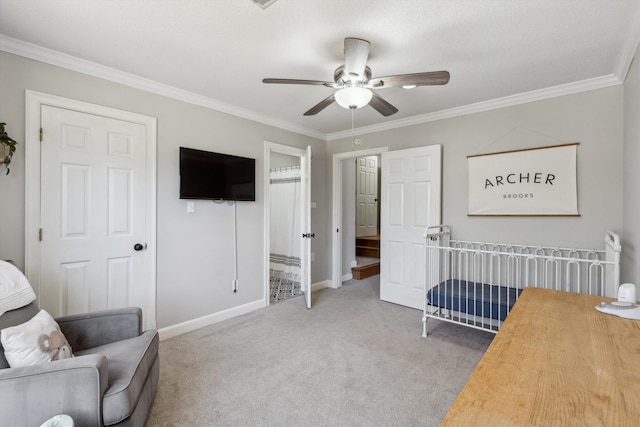 carpeted bedroom featuring ornamental molding, ceiling fan, and baseboards