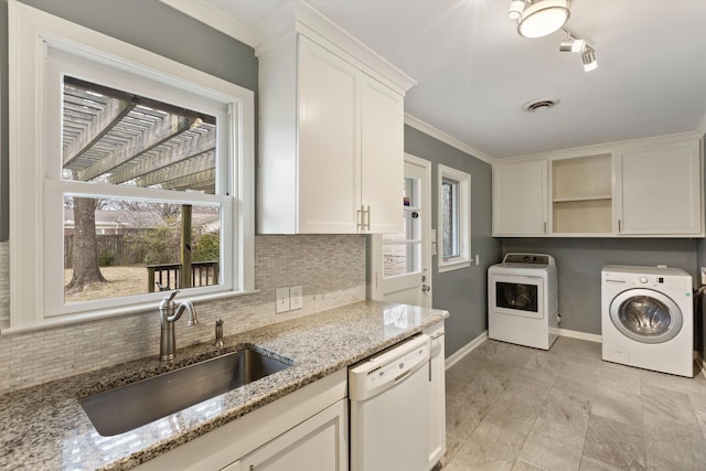 laundry area featuring laundry area, baseboards, visible vents, separate washer and dryer, and a sink