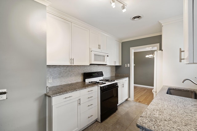 kitchen featuring white appliances, a sink, visible vents, white cabinetry, and backsplash