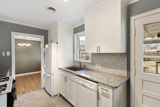 kitchen with white appliances, a sink, visible vents, and white cabinetry