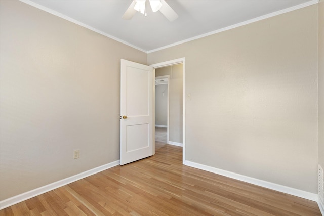 unfurnished room with light wood-style flooring, baseboards, ceiling fan, and ornamental molding