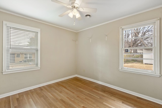 unfurnished room with baseboards, visible vents, light wood-style flooring, and crown molding