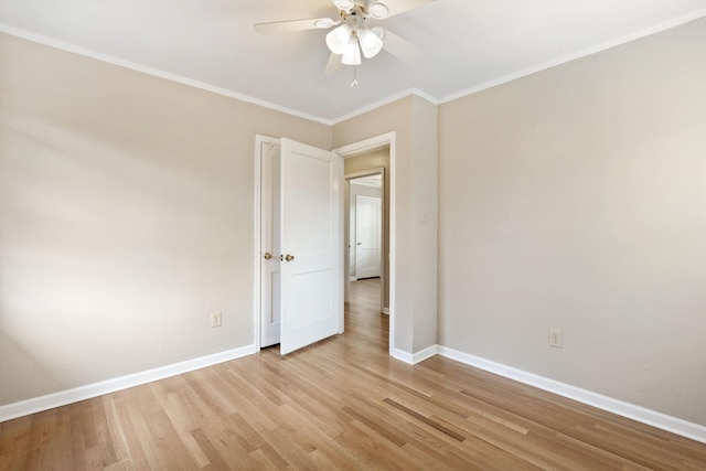 empty room featuring light wood-style floors, a ceiling fan, baseboards, and crown molding