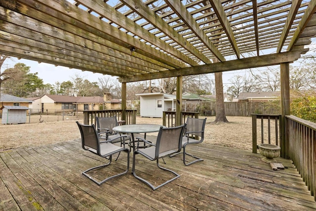 wooden terrace featuring a shed, outdoor dining space, a pergola, a fenced backyard, and an outdoor structure