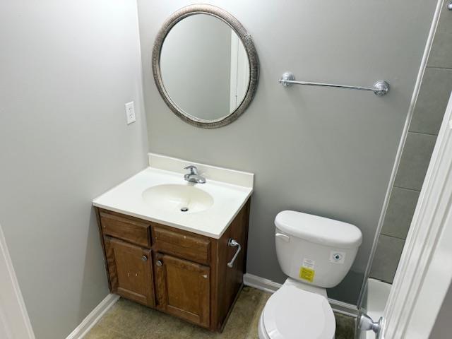 bathroom featuring toilet, baseboards, and vanity