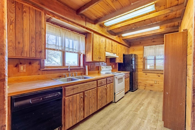 kitchen with beam ceiling, a sink, wooden walls, under cabinet range hood, and black appliances