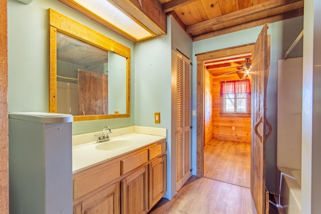 bathroom with wood ceiling, vanity, wood finished floors, beamed ceiling, and walk in shower