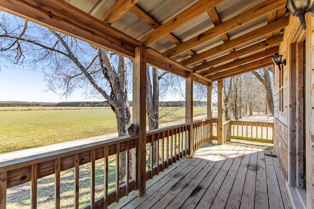 wooden terrace with a lawn and a rural view