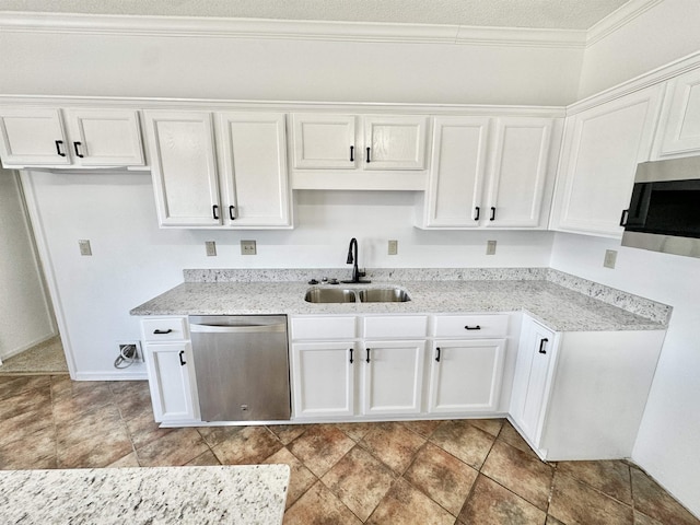 kitchen with appliances with stainless steel finishes, a sink, white cabinetry, and light stone countertops