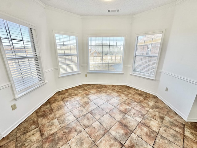 empty room featuring a textured ceiling, tile patterned flooring, visible vents, baseboards, and crown molding