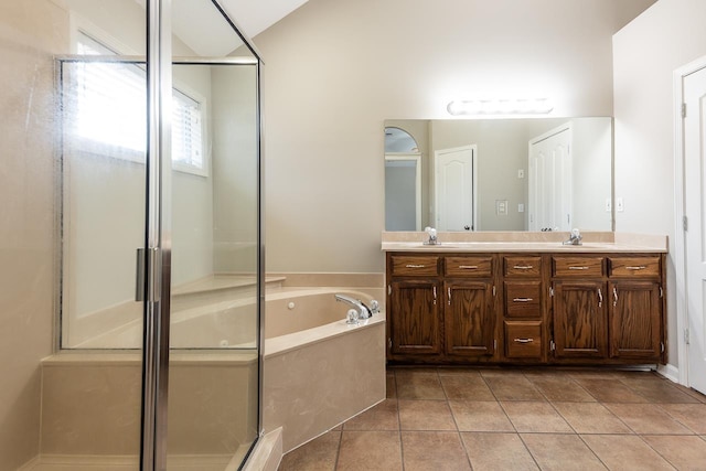 bathroom with double vanity, a stall shower, a bath, and tile patterned floors