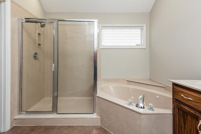 bathroom with a tub with jets, vanity, a shower stall, and tile patterned floors