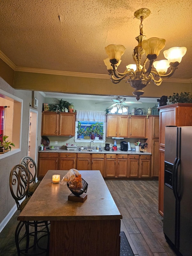 kitchen with dark wood-style floors, a notable chandelier, brown cabinetry, ornamental molding, and refrigerator with ice dispenser