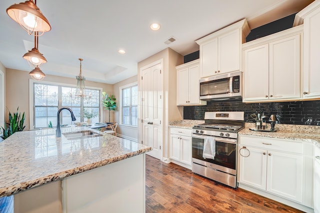 kitchen featuring tasteful backsplash, visible vents, appliances with stainless steel finishes, dark wood-style flooring, and a sink