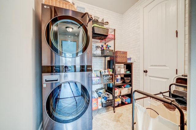 laundry area featuring stacked washer / dryer, laundry area, and tile patterned floors