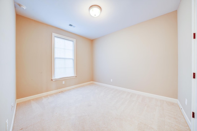 carpeted spare room featuring visible vents and baseboards