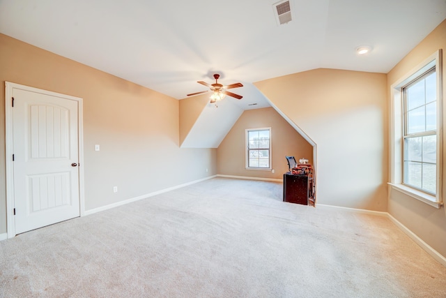 additional living space with carpet, visible vents, vaulted ceiling, ceiling fan, and baseboards