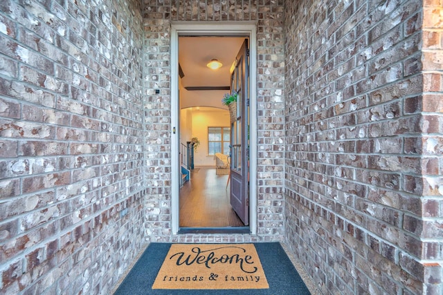 doorway to property featuring brick siding