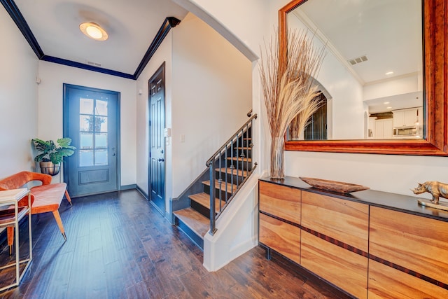 entrance foyer featuring ornamental molding, arched walkways, visible vents, and dark wood-style floors