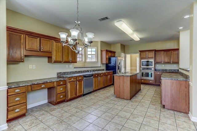 kitchen with visible vents, brown cabinetry, a kitchen island, decorative light fixtures, and stainless steel appliances