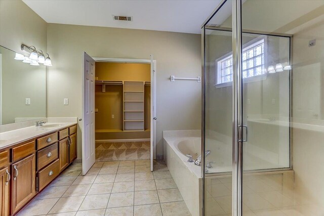 bathroom with visible vents, tile patterned flooring, vanity, a shower stall, and a bath