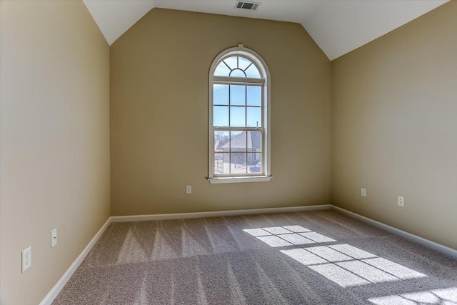 carpeted empty room featuring baseboards, visible vents, and vaulted ceiling