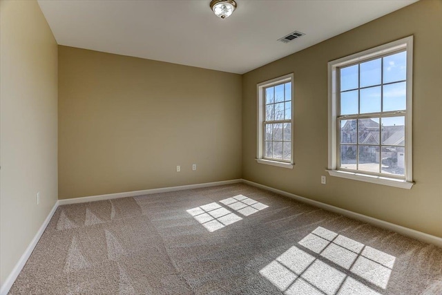 unfurnished room featuring carpet, visible vents, and baseboards