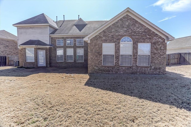 view of front of property with central AC, brick siding, and fence