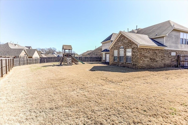 view of yard featuring a playground and a fenced backyard