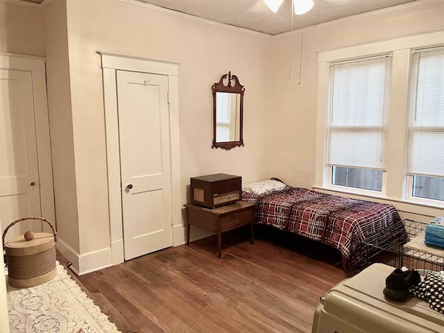 bedroom with multiple windows, crown molding, and wood finished floors