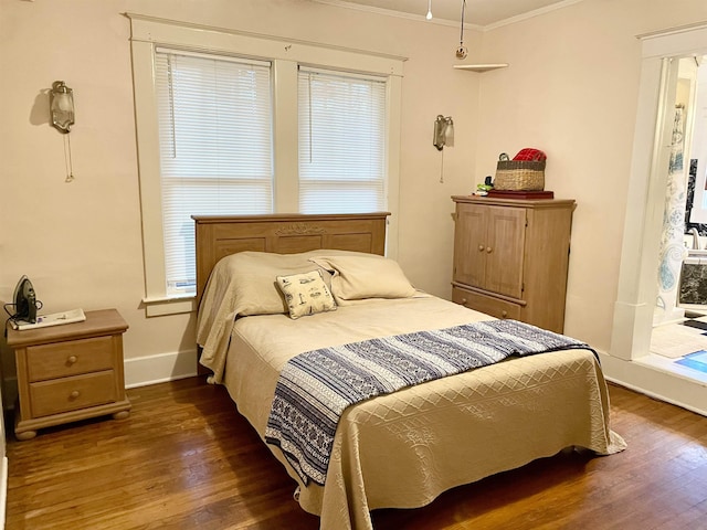 bedroom with ornamental molding, dark wood finished floors, and baseboards