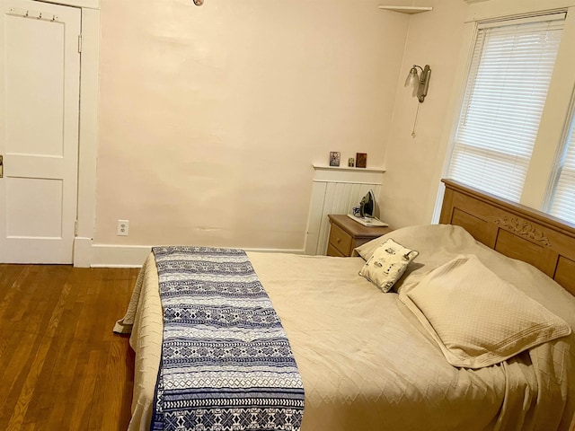 bedroom featuring wood finished floors and baseboards