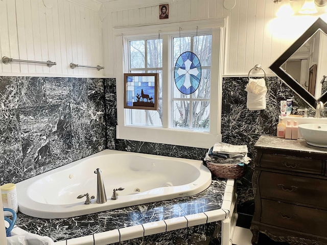 full bath with a whirlpool tub and vanity