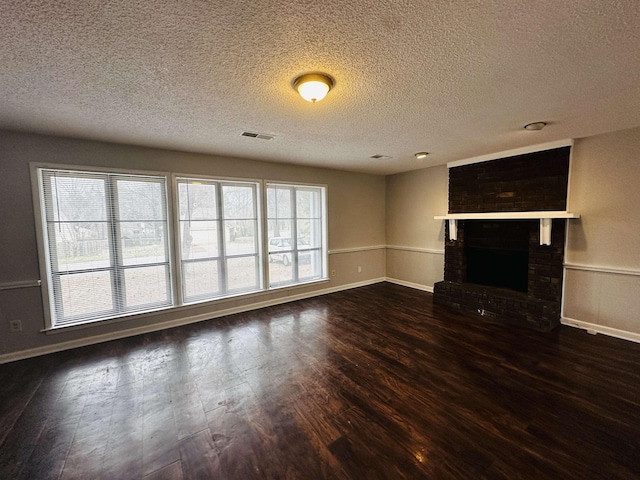 unfurnished living room featuring dark wood-style floors, a brick fireplace, visible vents, and baseboards