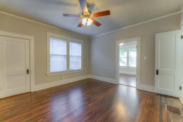 unfurnished room with ceiling fan, wood finished floors, visible vents, baseboards, and crown molding