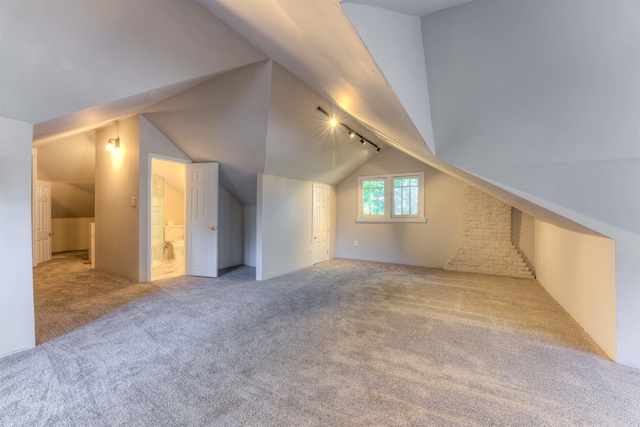 bonus room featuring vaulted ceiling and carpet