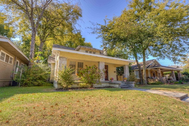 view of front of home with covered porch and a front lawn