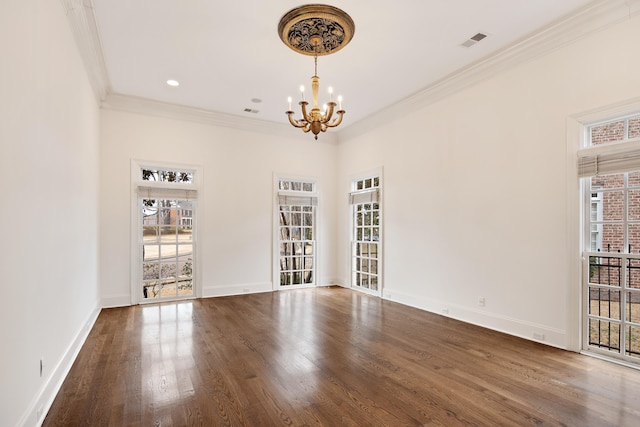 spare room featuring crown molding, visible vents, plenty of natural light, and wood finished floors