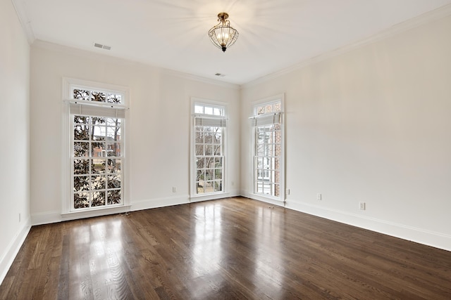 empty room featuring crown molding, visible vents, an inviting chandelier, wood finished floors, and baseboards