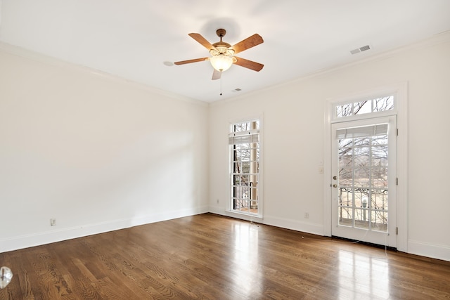 unfurnished room with baseboards, visible vents, wood finished floors, and ornamental molding