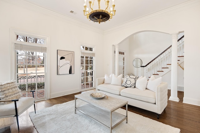 living area with ornate columns, crown molding, and wood finished floors