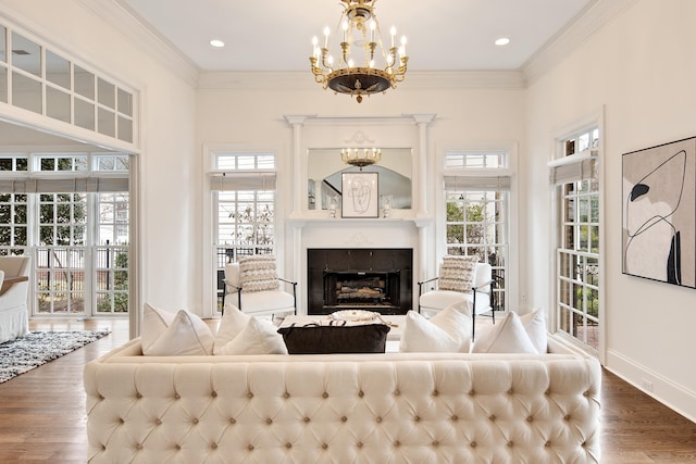 living room with crown molding, a fireplace, baseboards, and wood finished floors