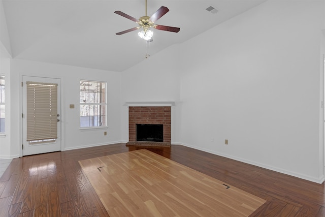 unfurnished living room with visible vents, baseboards, a ceiling fan, wood finished floors, and a brick fireplace