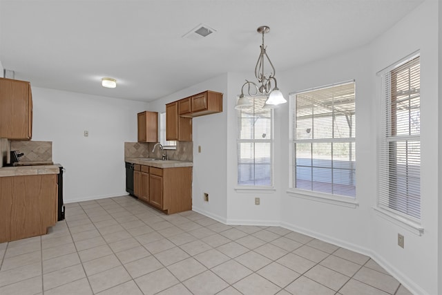 kitchen with black dishwasher, light countertops, visible vents, backsplash, and a sink