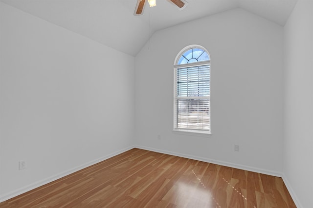 unfurnished room with lofted ceiling, wood finished floors, a ceiling fan, and baseboards